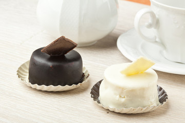 chocolate pastry little cake with tea cup on  wooden table