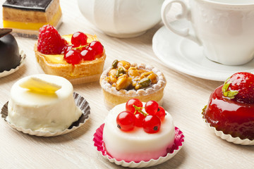 Different sort of beautiful pastry, small colorful sweet cakes