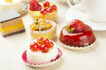 Different sort of beautiful pastry, small colorful sweet cakes