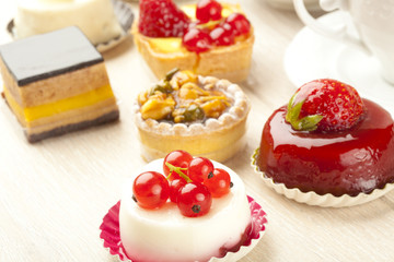 Different sort of beautiful pastry, small colorful sweet cakes