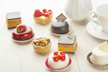 Different sort of beautiful pastry, small colorful sweet cakes