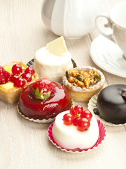 Different sort of beautiful pastry, small colorful sweet cakes