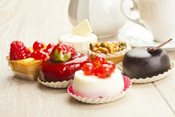 Different sort of beautiful pastry, small colorful sweet cakes