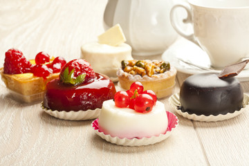Different sort of beautiful pastry, small colorful sweet cakes