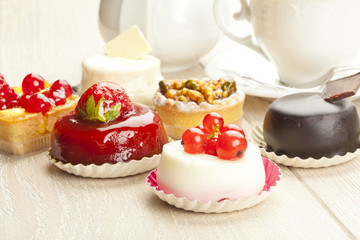 Different sort of beautiful pastry, small colorful sweet cakes