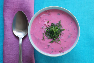 Chłodnik - cold beetroot soup in a bowl on a tablecloth