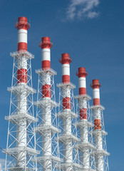 Five high color industrial smoke pipes diagonal view