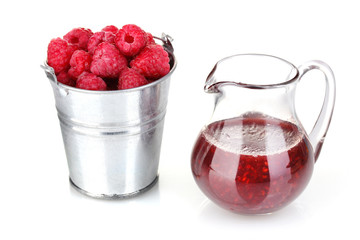 Raspberries in metal bucket and jug with jam isolated on white
