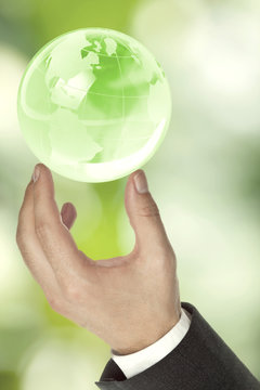Businessman holding green globe - ecology or environment concept