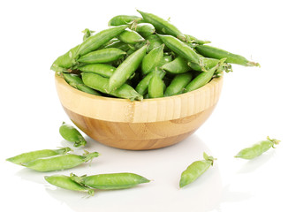 Green peas in wooden bowl isolated on white