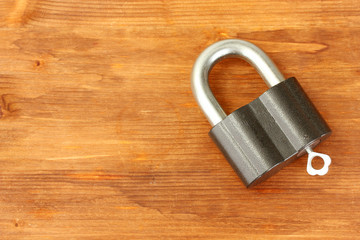 Fototapeta premium old padlock with key on wooden background close-up