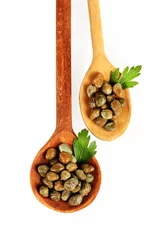 Zelfklevend Fotobehang green capers in wooden spoons on white background close-up © Africa Studio
