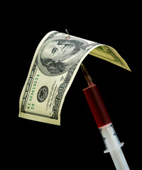 one hundred dollars and syringe isolated on a black background