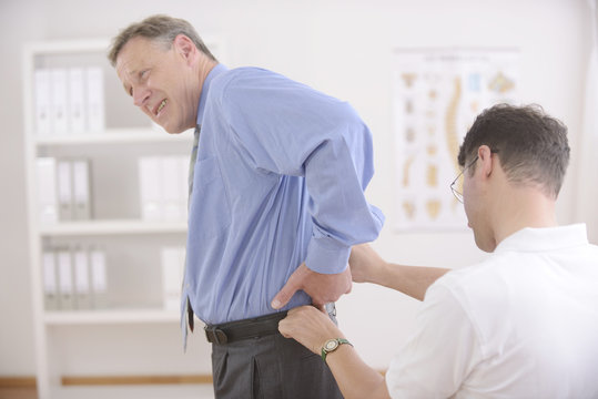 Chiropractic: Chiropractor examining senior man