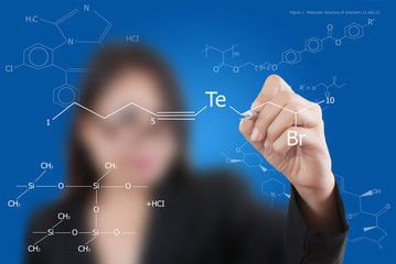 Teacher lady writing scientific formula on the whiteboard.