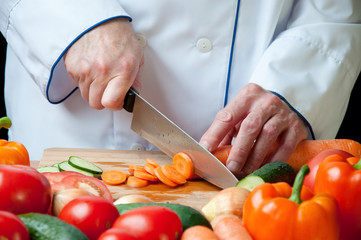 Horizontal shot of chef's hands chopping carrot