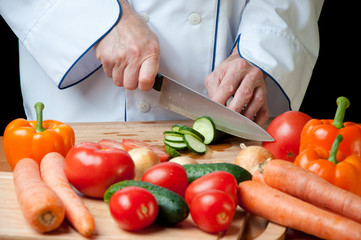 Chef cutting a fresh cucumber, studio shot