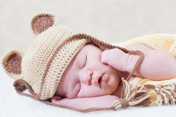sleeping newborn baby with a ridiculous knitted hat