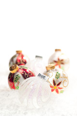 Glass Christmas baubles on snow