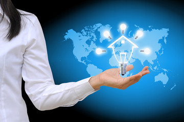 working women hand holding a light bulb model of a house