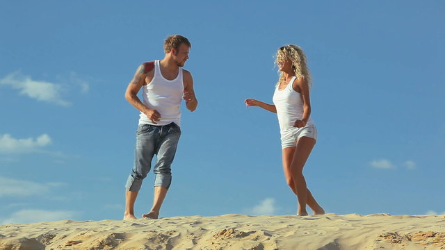 Happy slim couple dancing at the beach  together