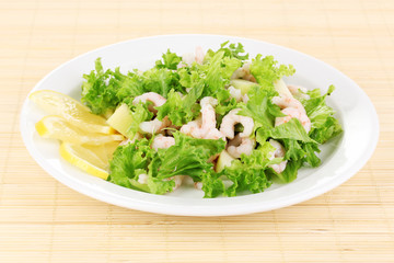 Delicious marinated shrimp in plate on bamboo mat