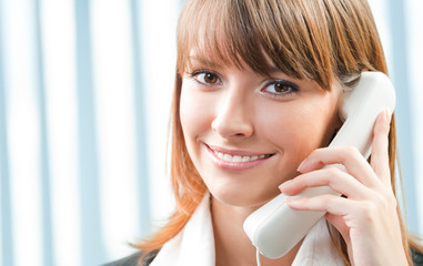 Young business woman with phone at office