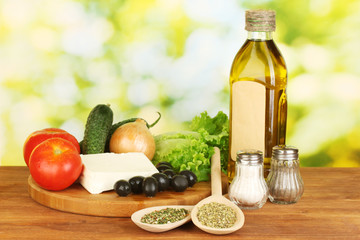 Ingredients for a Greek salad on green background close-up
