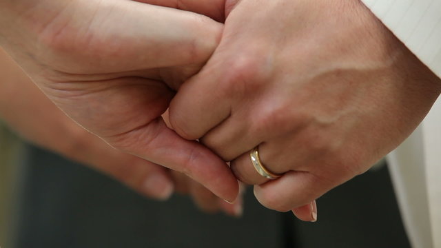 Bride and fiance holding hands during the wedding ceremony