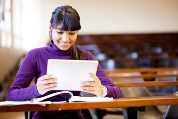 happy female indian college student using tablet computer