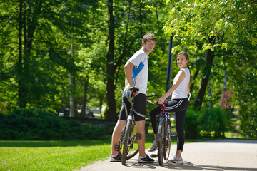 Happy couple riding bicycle outdoors