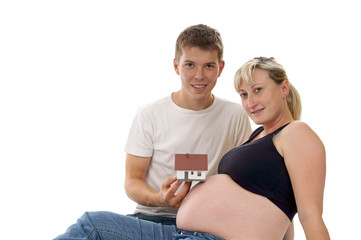 pregnant woman with her man and a little house