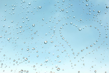 Heart from gentle droplets of a rain on clean transparent glass