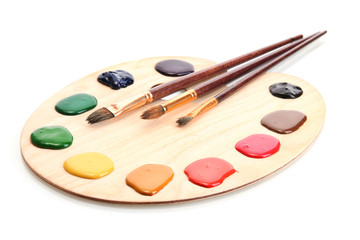 wooden art palette with  paint and brushes.isolated on white