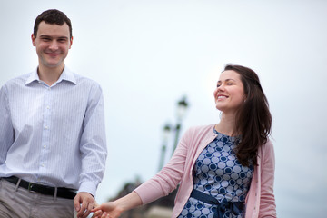 Closeup of happy dating couple walking hand in hand