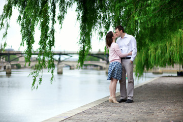 Fototapeta na wymiar Romantic dating couple is kissing under the willow