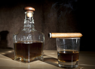 smoking cigar  and glass whiskey on dark background