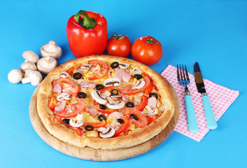 Aromatic pizza with vegetablesand mushrooms on blue background