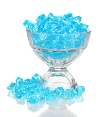 A glass with blue decorative stones isolated on white