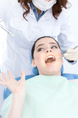 Dentist's assistant checks up the teeth of the patient