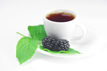 cup of tea and  blackberry with leaves on white background