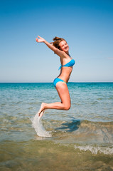young girl jumping out of a water