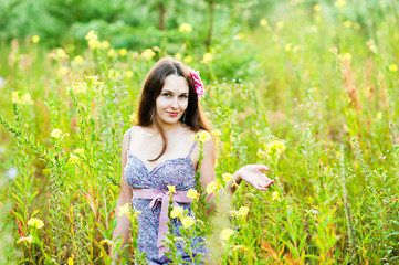 Naklejka na ściany i meble beautiful girl in a field of flowers
