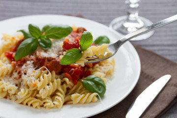 Fusilli pasta with sauce bolognese hanging on a fork.