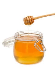 Jar of honey with wooden drizzler