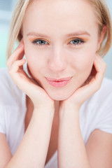 portrait of happy young woman resting her head in her hands