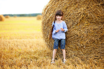Naklejka na ściany i meble Little girl and big haystack