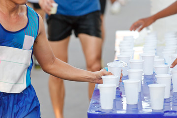 Marathon racer catching cup of water