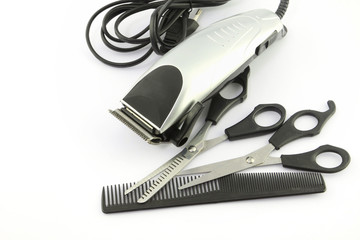 hair clipper, comb and scissors on white background