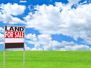 Real estate conceptual image - "FOR SALE" sign on empty meadow